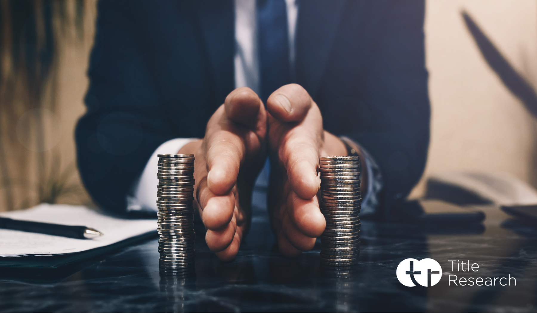Man in a suit separating two stacks of coins with his hands