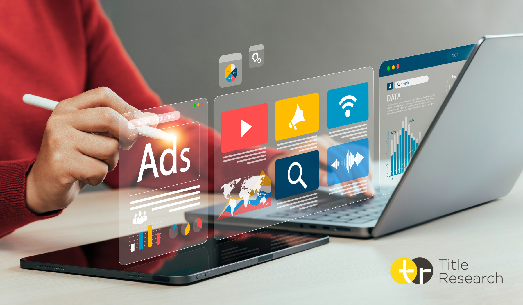 Person using a stylus to touch graphics coming from a laptop and tablet screen